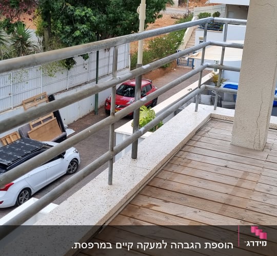 מעקה מתכת במרפסת עם רצפת עץ
